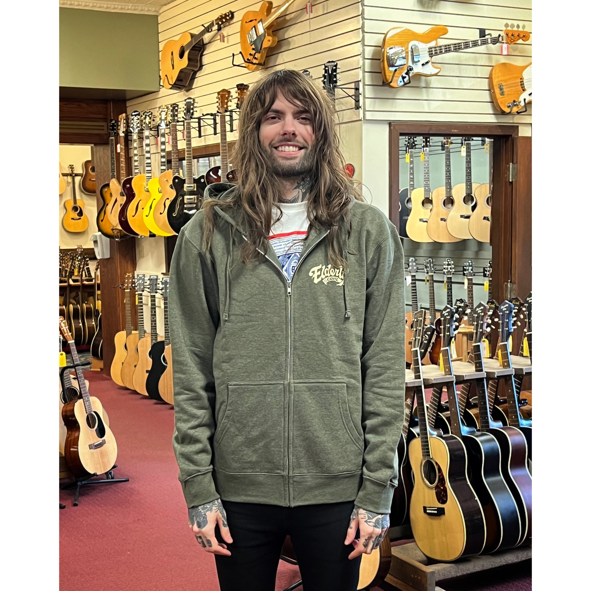 Elderly Staff Member in the Showroom with the Heathered Olive Elderly Logo Zip Up Hoodie